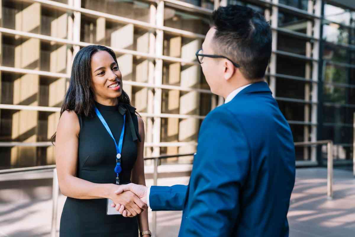 Optimistic business woman shaking hands with a male