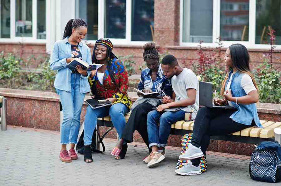 Group of five african college students spending time together in a campus