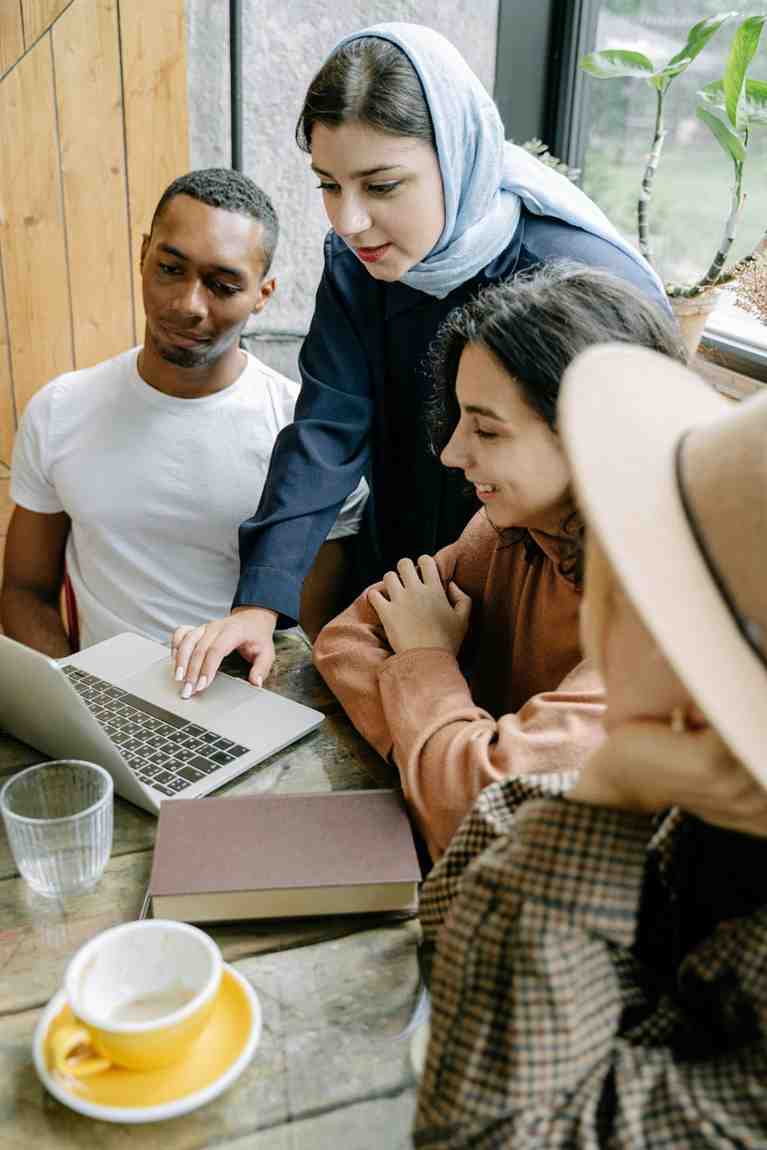 Lady in hijab on computer with diverse group of students